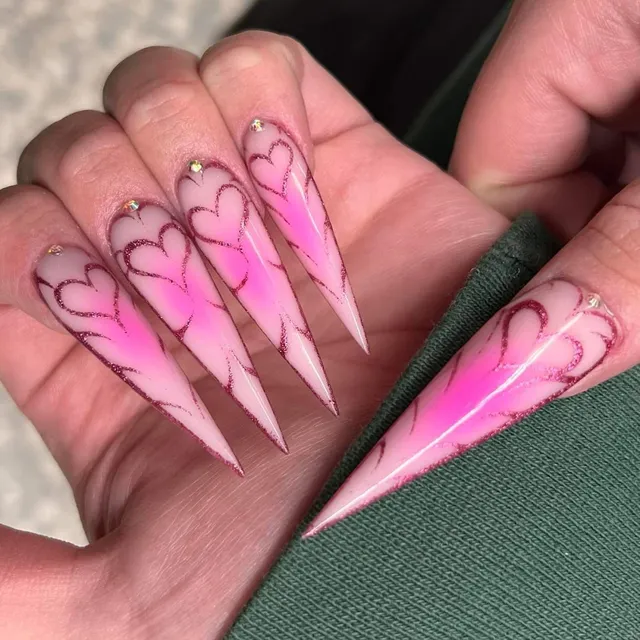 Glossy pink stiletto nails with heart detailing